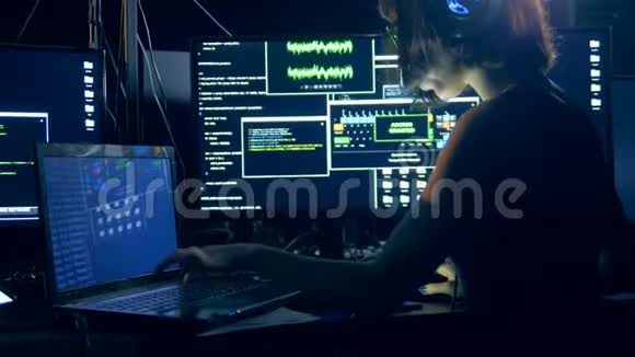 一位年轻女子正在使用笔记本电脑和电脑进行黑客攻击视频的预览图