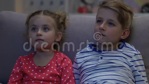 男孩和女孩在晚上看电视当父母突然回家时害怕视频的预览图