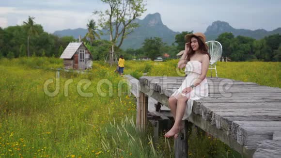 泰国洛普布里一位妇女在木桥上与田野作伴视频的预览图