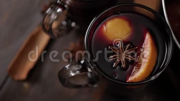 顶部的玻璃杯与覆盖葡萄酒在棕色木制背景在葡萄藤表面的八角星和一片橙色视频的预览图