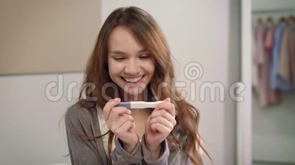 幸福女人持有阳性妊娠试验女性产妇宝宝出生视频的预览图
