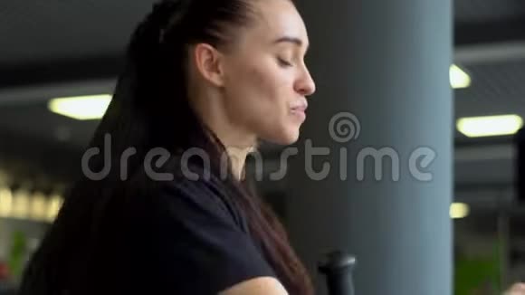 肖像健身女子健身俱乐部椭圆交叉教练训练前热身视频的预览图