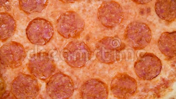 比萨饼特写俯视图与萨拉米和奶酪马苏里拉4k镜头意大利香肠比萨质地的慢旋转视频的预览图