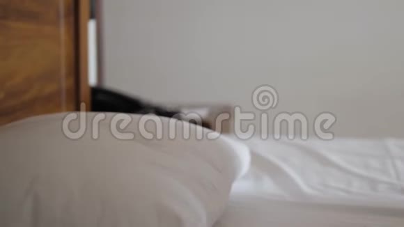 一个快乐的年轻美女侧卧在床上她把头靠在枕头上特写镜头视频的预览图