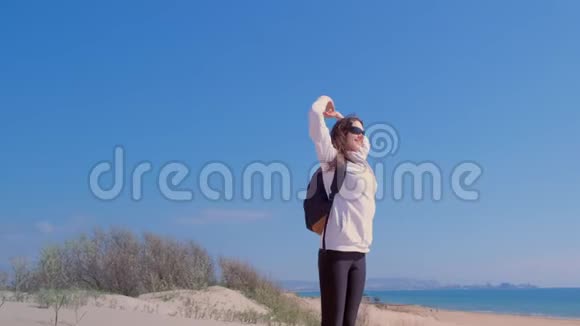 幸福的女人举起她的手臂在沙滩沙丘之上在海滩赢家的概念视频的预览图