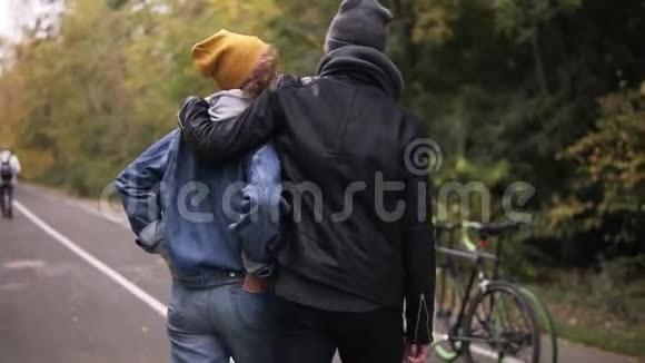 秋天公园的城市公园里一对可爱的年轻夫妇抱着自行车开始散步积极生活方式的概念视频的预览图
