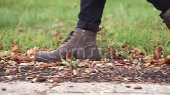 在秋天的公园里穿着时髦的皮靴的人走着视频的预览图