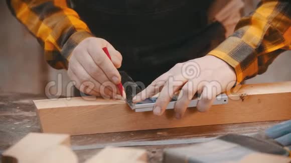木工一名木工用铅笔和标尺在木刻上做记号视频的预览图