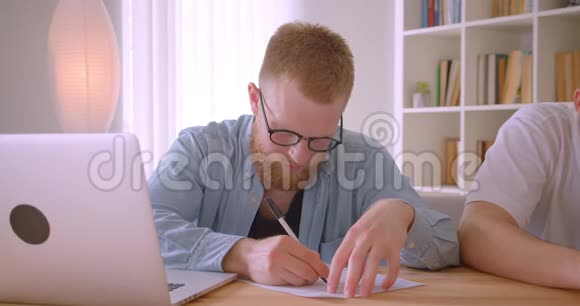 在办公室室内签署文件的白种人成年商人的特写肖像视频的预览图