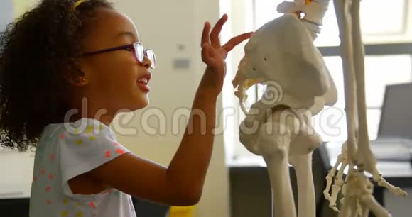4k教室中非裔美国女学生学习人体骨骼的侧面观察视频的预览图