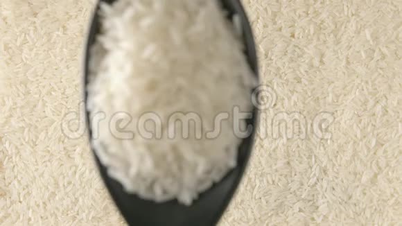 俯视图用勺子盛着白米慢动作地落在米饭上视频的预览图