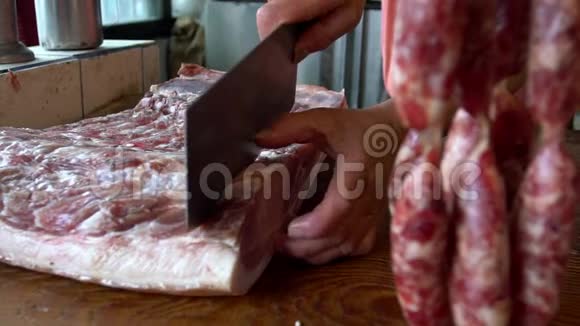 在切大块猪肉时用斧子拖住小贩的慢动作视频的预览图