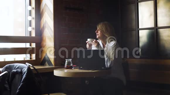 坐在咖啡馆里喝茶的女商人视频的预览图