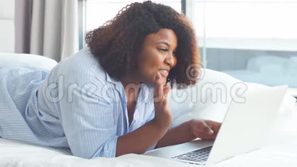 快乐丰满的女人在网上和朋友聊天非洲家庭主妇是一个博主视频的预览图