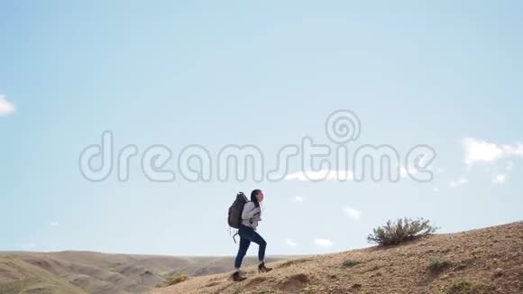 快乐的女人徒步旅行者独自踏上沙漠视频的预览图