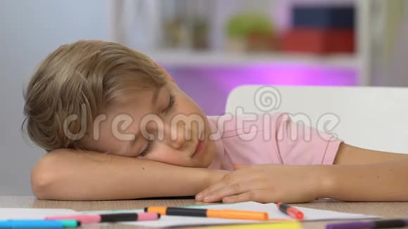 男孩睡在桌子旁画画后很累梦想成为著名的艺术家视频的预览图
