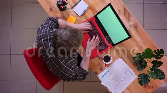 一位年轻的高加索商人在办公室室内打字和喝咖啡的特写镜头视频的预览图