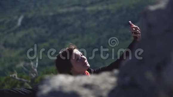在山顶上用智能手机拍照的旅游女孩视频的预览图