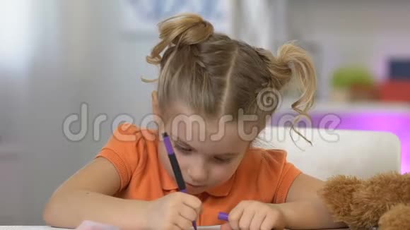 可爱的小女孩在玩具玩具熊上画画玩视频的预览图