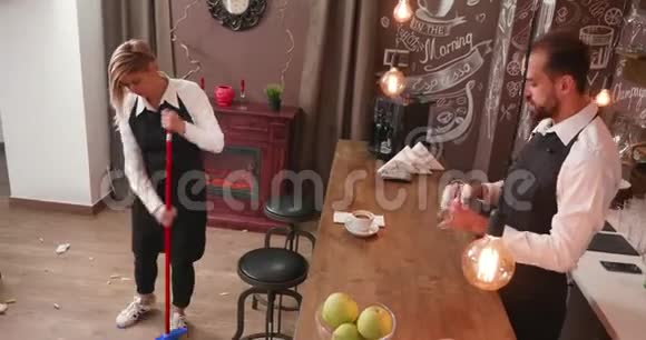 女服务员用扫帚扫餐馆的地板视频的预览图