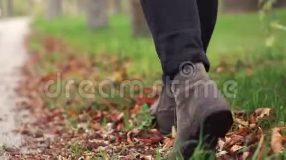 在秋天的公园里穿着时髦的皮靴的人走着视频的预览图