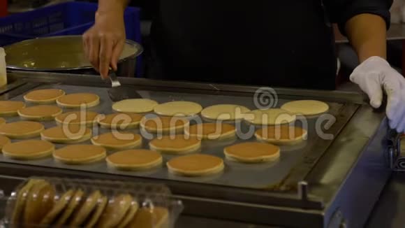 亚洲路边摊上的慢动作小贩正在烹调多拉崎亚洲煎饼视频的预览图