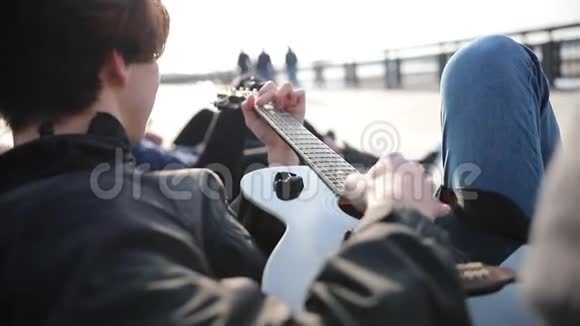 一个躺在长凳上弹吉他的年轻人视频的预览图