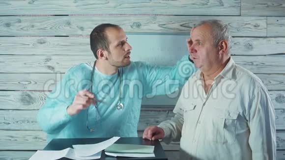 眼科医生检查一名老年男性病人的眼睛视频的预览图