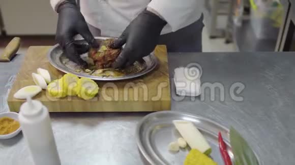 专业厨师在餐厅厨房特写镜头中在烤箱中烘烤之前先用酱油浇生肉视频的预览图
