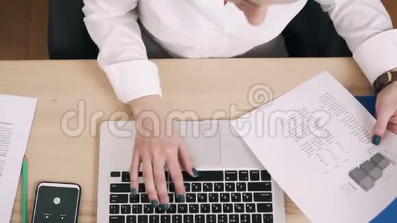 女青年在办公室工作场所使用电脑俯视图视频的预览图
