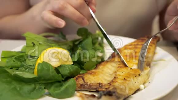人正在餐厅里用叉子和刀吃炸鱼菜特写视频的预览图