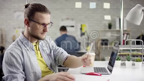 相机在自由职业者手在笔记本电脑键盘上慢动作的滑动在办公室工作的商人视频的预览图