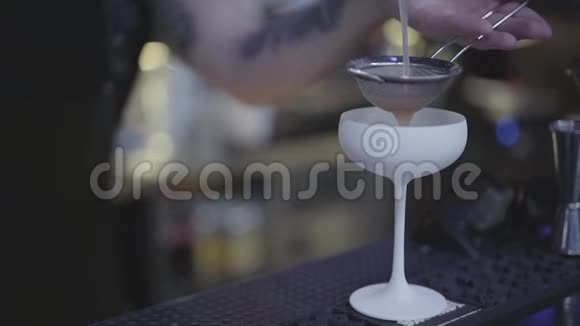 调酒师的手在令人惊叹的白色鸡尾酒杯中通过染色剂注入液体联合调酒师视频的预览图