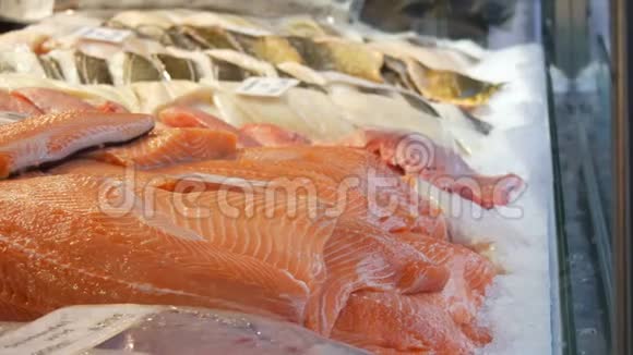 鱼店的展示冰块中巨大的红鱼出售鲑鱼和其他海鱼片视频的预览图