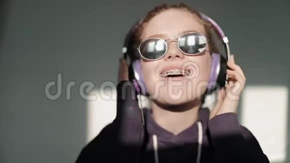 戴着牙套的年轻女孩喜欢音乐视频的预览图