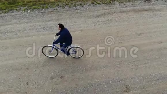 骑自行车的公路自行车骑自行车的人从顶部鸟瞰从上面射击人骑自行车在空路上视频的预览图