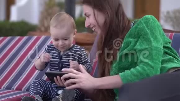 妈妈和宝宝开心地在智能手机上看视频跳舞视频的预览图
