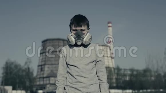年轻男孩戴着呼吸器用手机对抗工厂烟囱空气污染概念切尔诺贝利视频的预览图