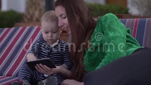 婴儿点击智能手机坐在他妈妈慢动作视频的预览图