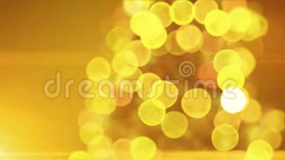美丽的金色圣诞树灯光闪烁和旋转特写在蓝色的博克在黄色的背景装载3d视频的预览图