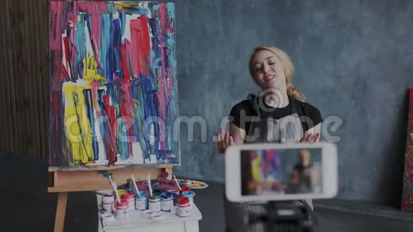 年轻漂亮的女画家博客在大气艺术的工作场所与她的追随者交流视觉演示视频的预览图