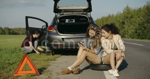 断轮男子换轮胎帮助两名女性朋友寻找帮助视频的预览图