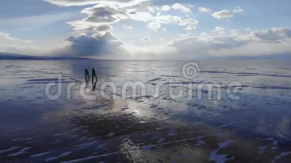 一对年轻的旅行者在冰冻的无边湖的冰上滑冰视频的预览图