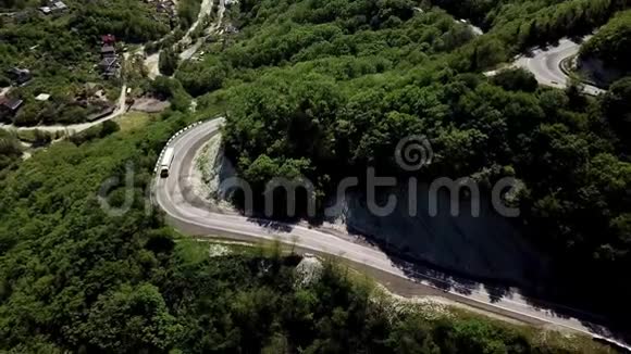 用汽车和POV卡车在山间的弯曲蜿蜒的道路的空中景观视频的预览图