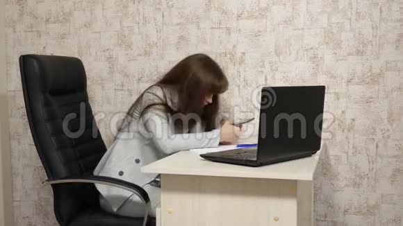 办公室里的女人在工作场所打哈欠疲惫的女孩想在工作时睡在桌子上女商人是视频的预览图