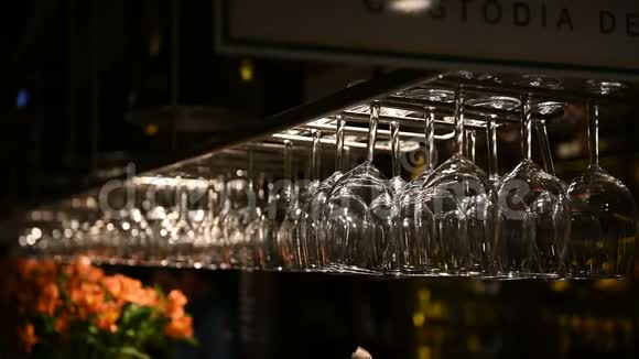 干净的酒杯倒挂在餐厅的吧台架上酒保擦杯子视频的预览图