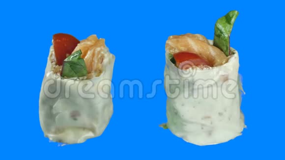 特写两片生鱼片寿司卷在一个孤立的蓝色背景上旋转成一个圆圈视频的预览图