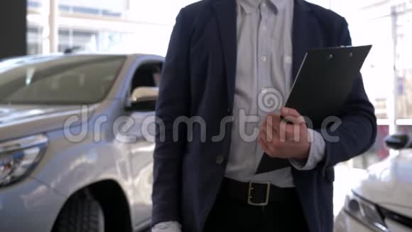 汽车经销商汽车经理男性手里拿着新汽车的钥匙在展厅出售视频的预览图