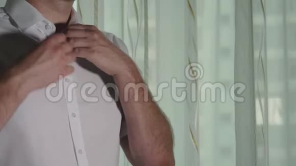 男士双手解开白色衬衫上的纽扣视频的预览图