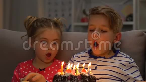 两个孩子在生日蛋糕上吹蜡烛朋友微笑庆祝视频的预览图